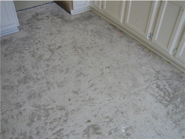 BEFORE- Cracked and pitted floor w/ tile glue